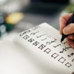 Hand hakt Aufgaben auf einer To-do-Liste ab
